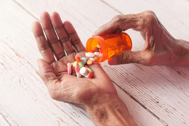 Hands holding colorful pills from bottle