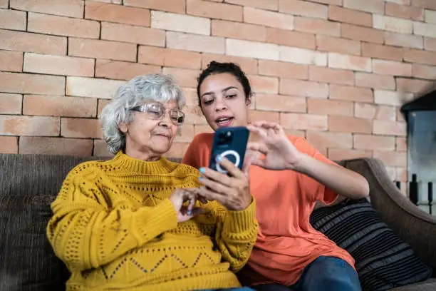 Woman helping elderly woman with smartphone